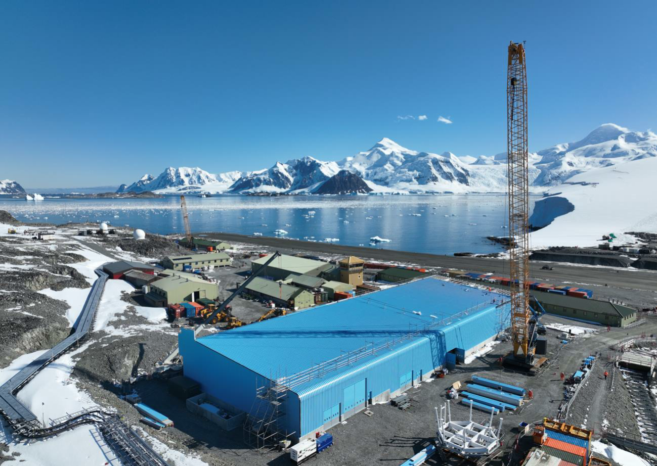 A large blue building with a snow covered mountain in the background