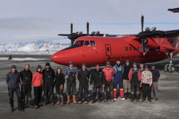 A group of people standing around a plane
