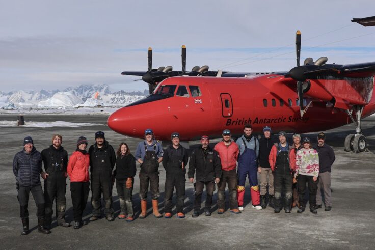 A group of people standing around a plane
