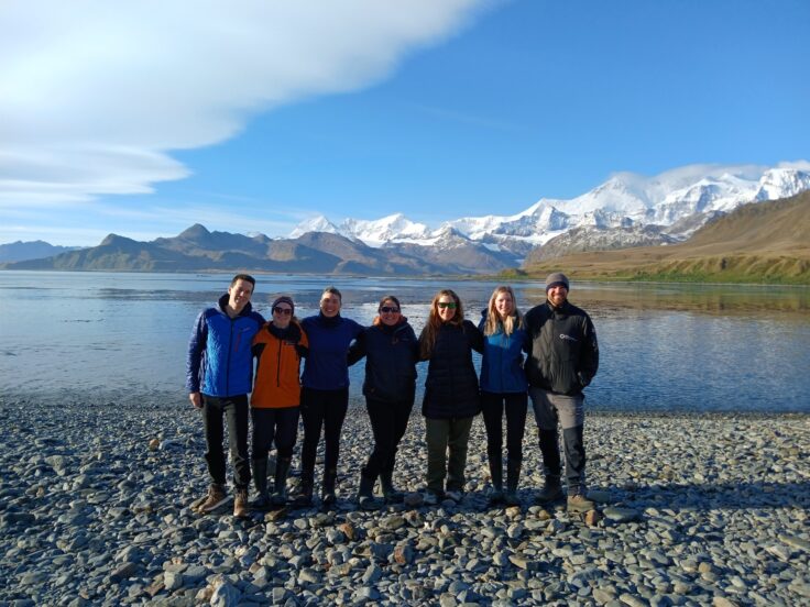 A group of people standing on a beach posing for the camera