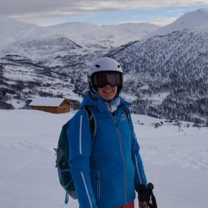 A person standing on top of a snow covered mountain