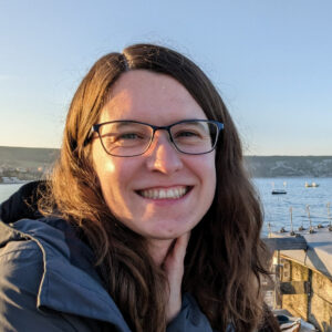 A person smiling next to a body of water