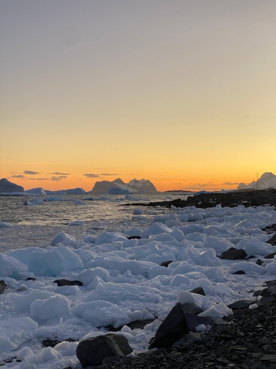 A snow covered landscape at sunset
