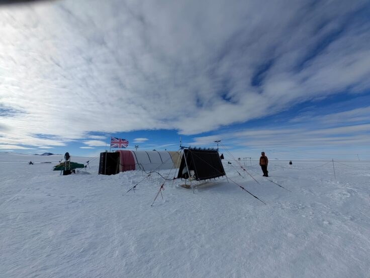 Ice covered ground with a cloudy sky above.