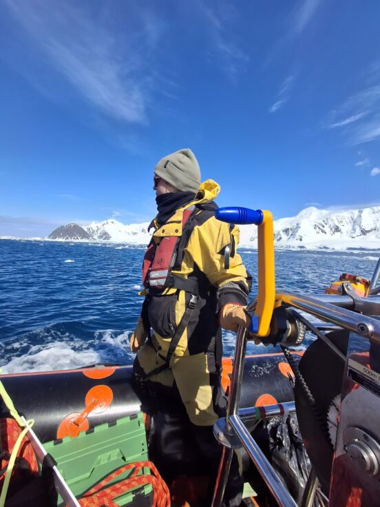A scientists stood on a small boat in the Southern Ocean