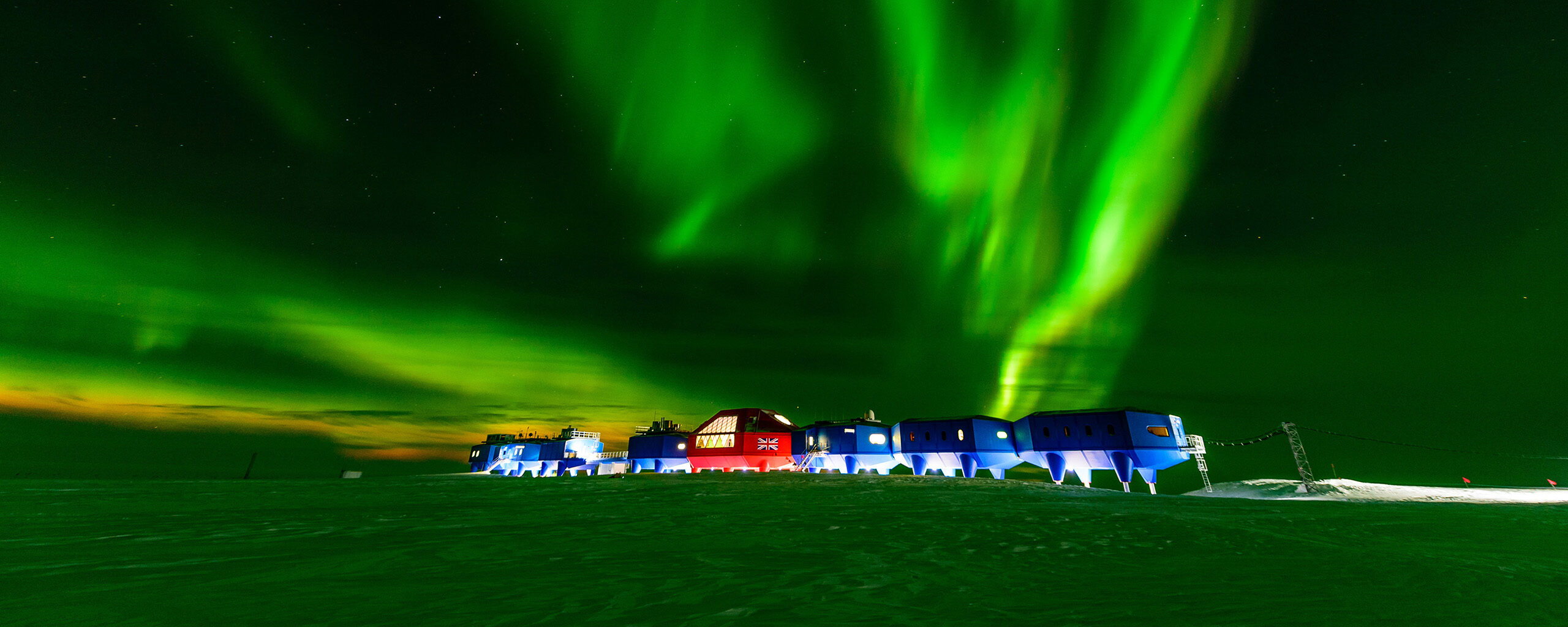 A green aurora illuminating Halley Research Station in Antarctica