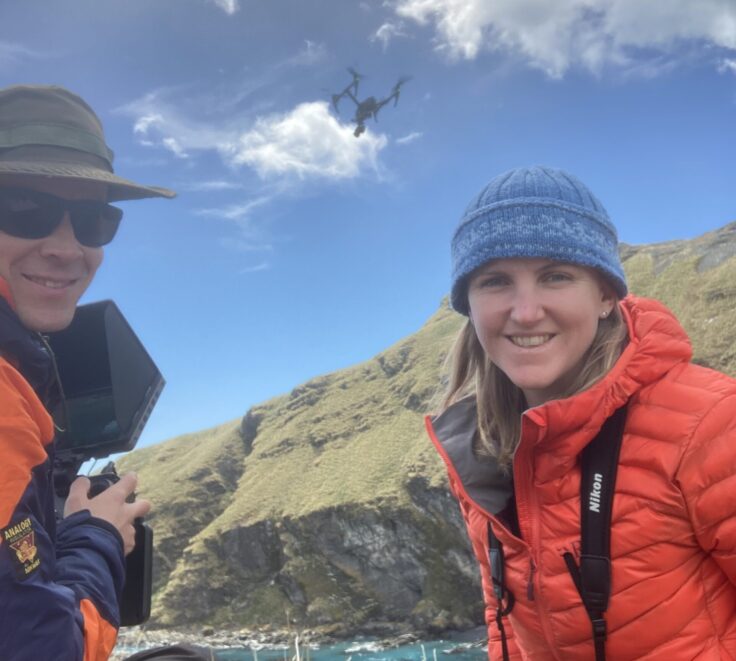 A man and a woman sitting on top of a mountain
