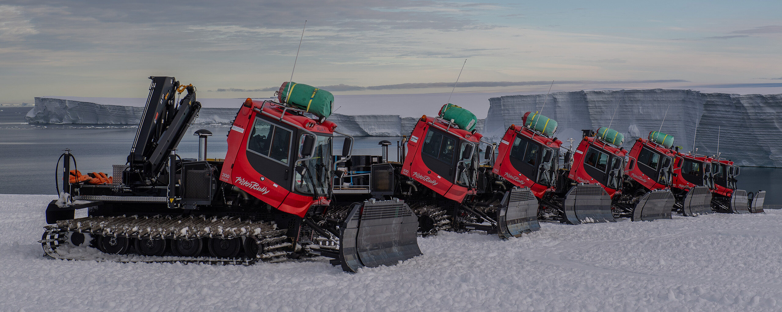 A line of PistenBullies working on the Antarctic Ice Shelf