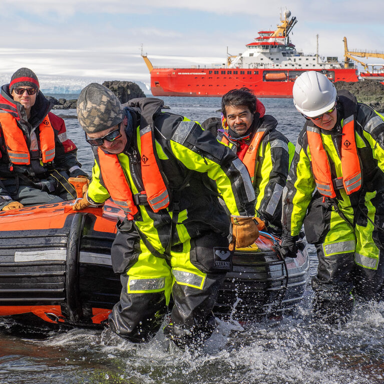 A group of people on a RIB deploying from the RRS Sir David Attenborough