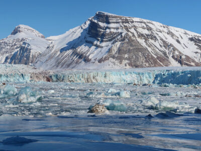 A snow covered mountain with a glacial fjord