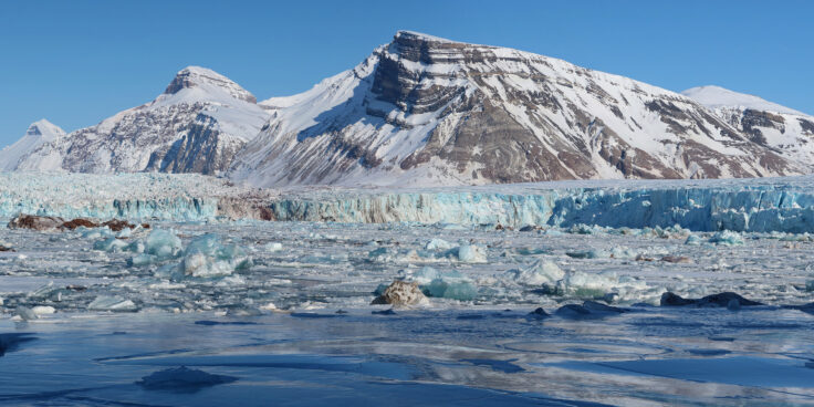 A snow covered mountain with a glacial fjord