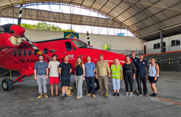 A group of people standing around a plane
