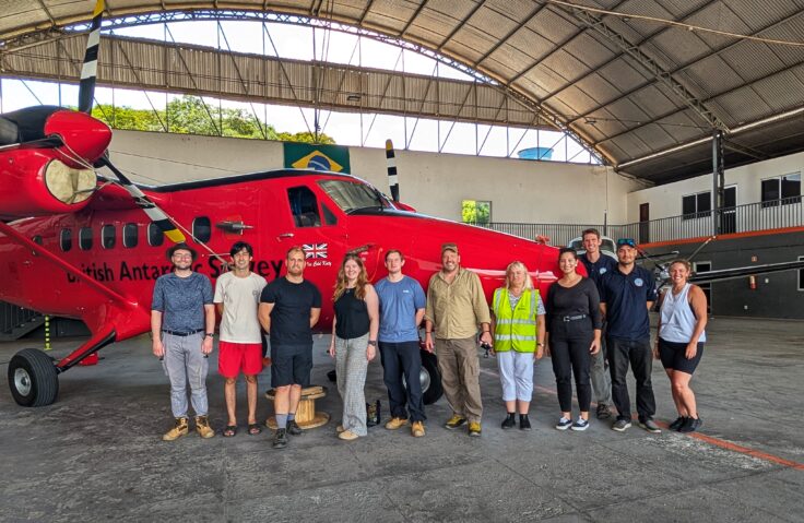 A group of people standing in front of one of the Twin Otter aircraft