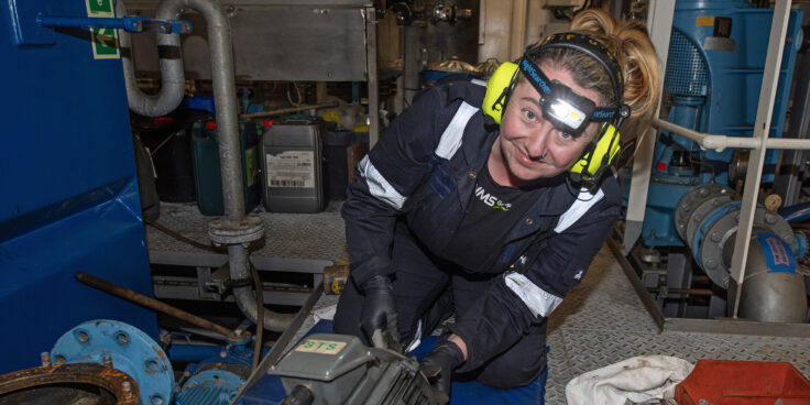 A female engineer working in a confined space with the aid of a head torch