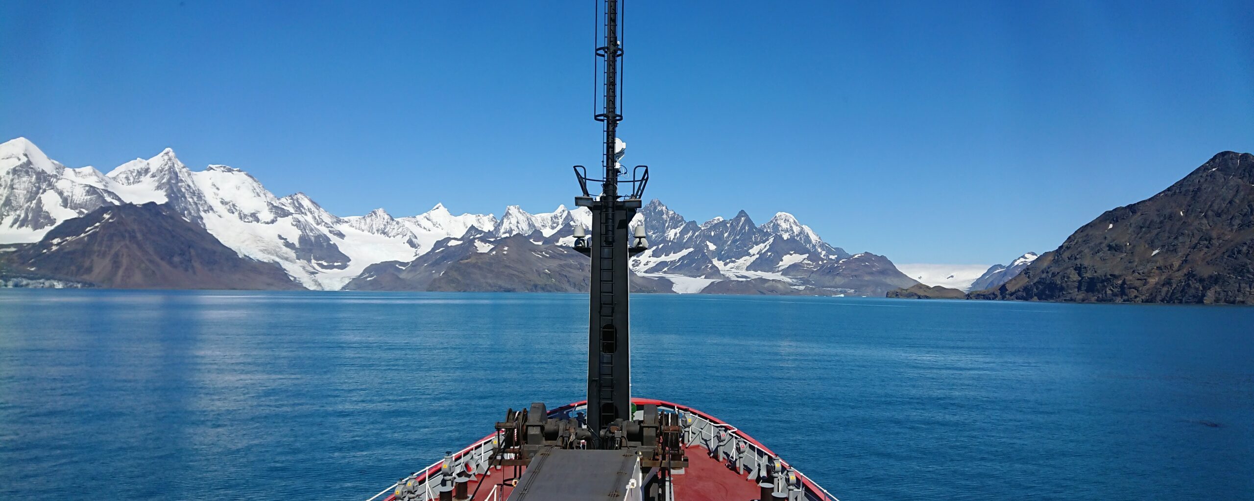 A boat on a body of water with a mountain in the background