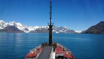 A boat on a body of water with a mountain in the background
