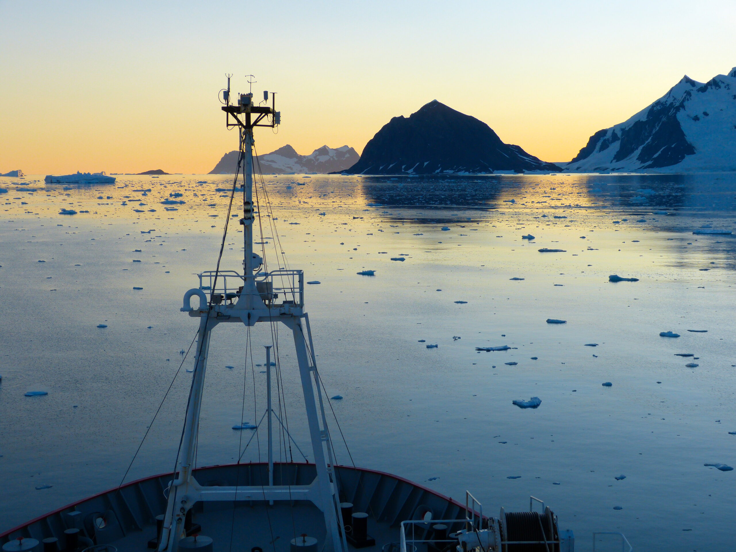 A view over a ship in a calm, icy bay