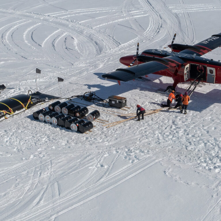 A BAS Twin Otter aircraft loading at a remote field location on the English Coast, Antarctica