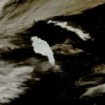 A large waterfall over a body of water