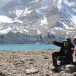 A man sitting on top of a snow covered mountain