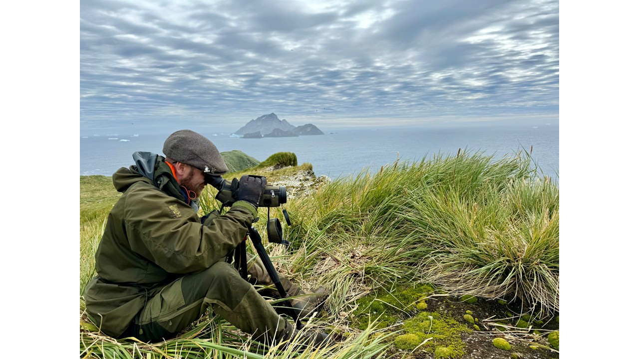 A man sitting next to a body of water
