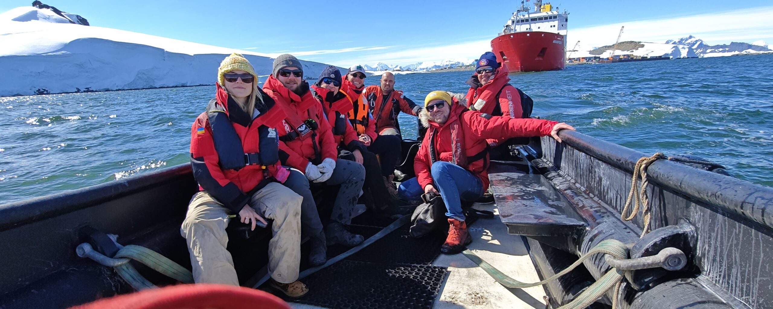 A group of people sitting on a boat next to a body of water