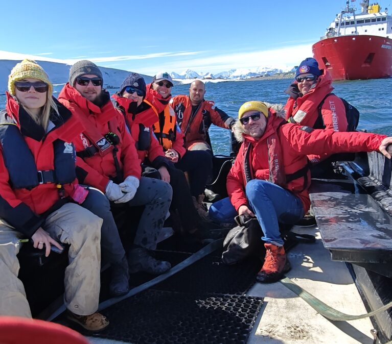 A group of people sitting on a boat next to a body of water