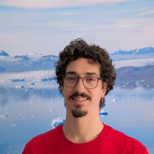 A man posing in front of a body of water