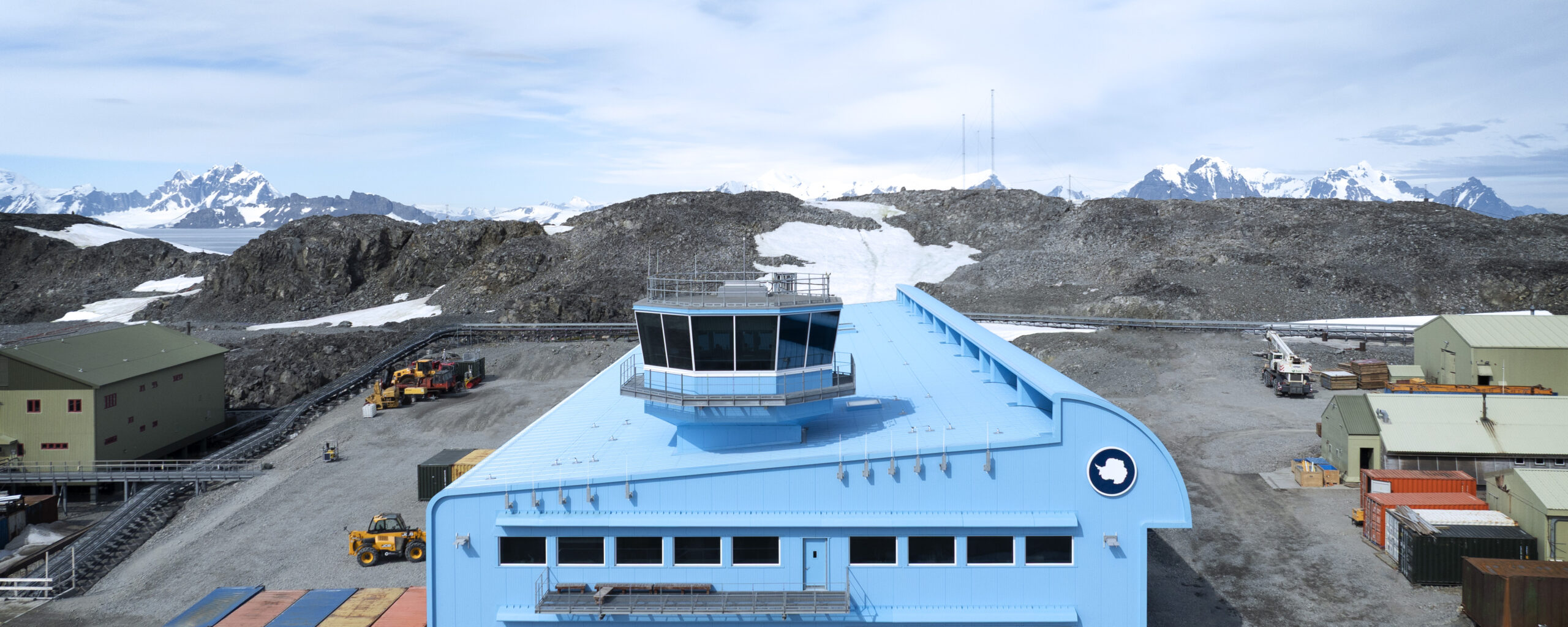 A large blue building with snow nearby
