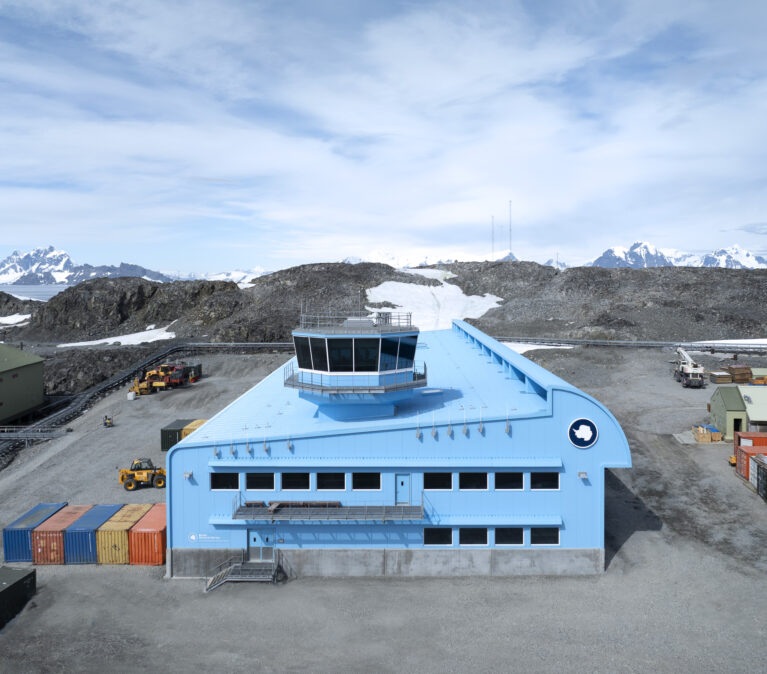 A large blue building with snow nearby