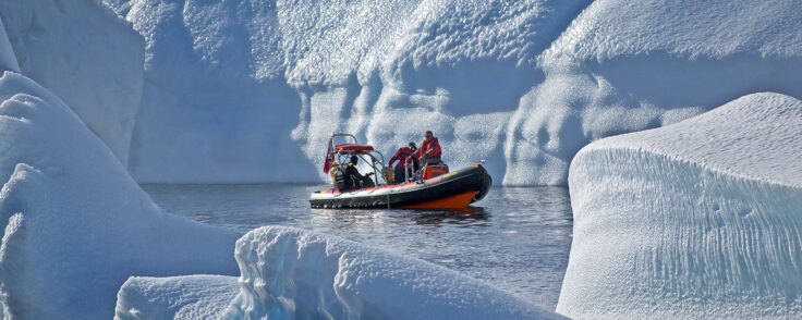 A man riding on the back of a boat in the water