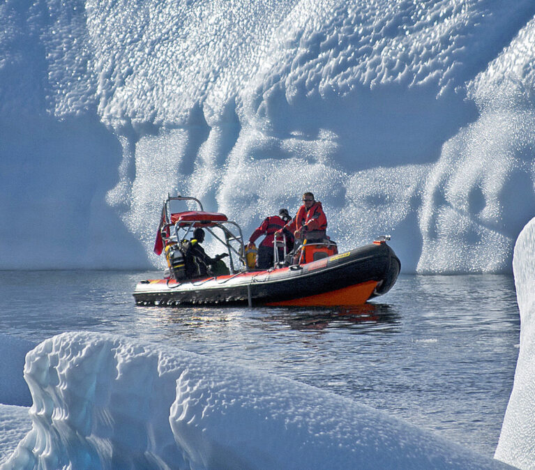 A man riding on the back of a boat in the water