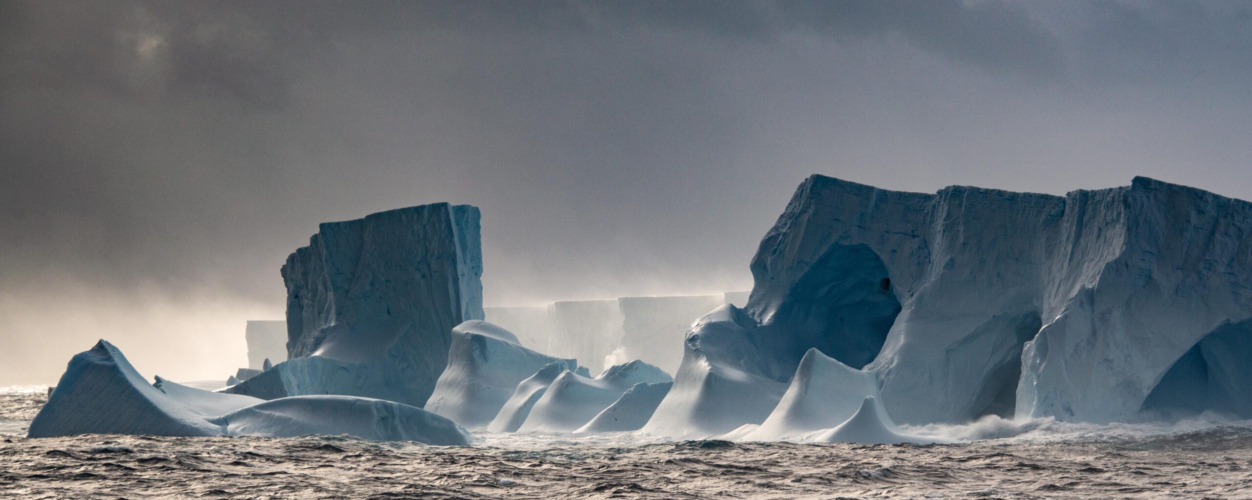 Eroded ice caves at edge of giant iceberg A23a, floating on ocean