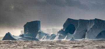 Eroded ice caves at edge of giant iceberg A23a, floating on ocean
