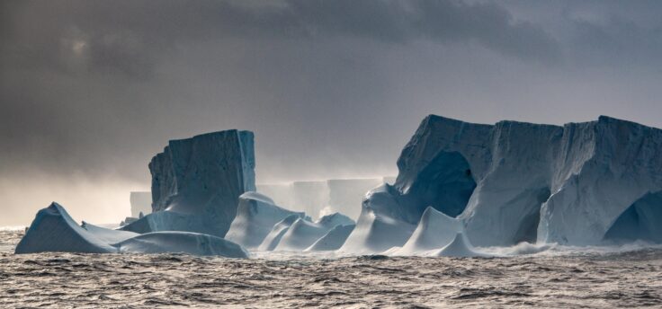 Eroded ice caves at edge of giant iceberg A23a, floating on ocean