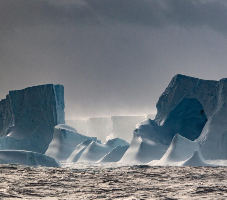 Eroded ice caves at edge of giant iceberg A23a, floating on ocean