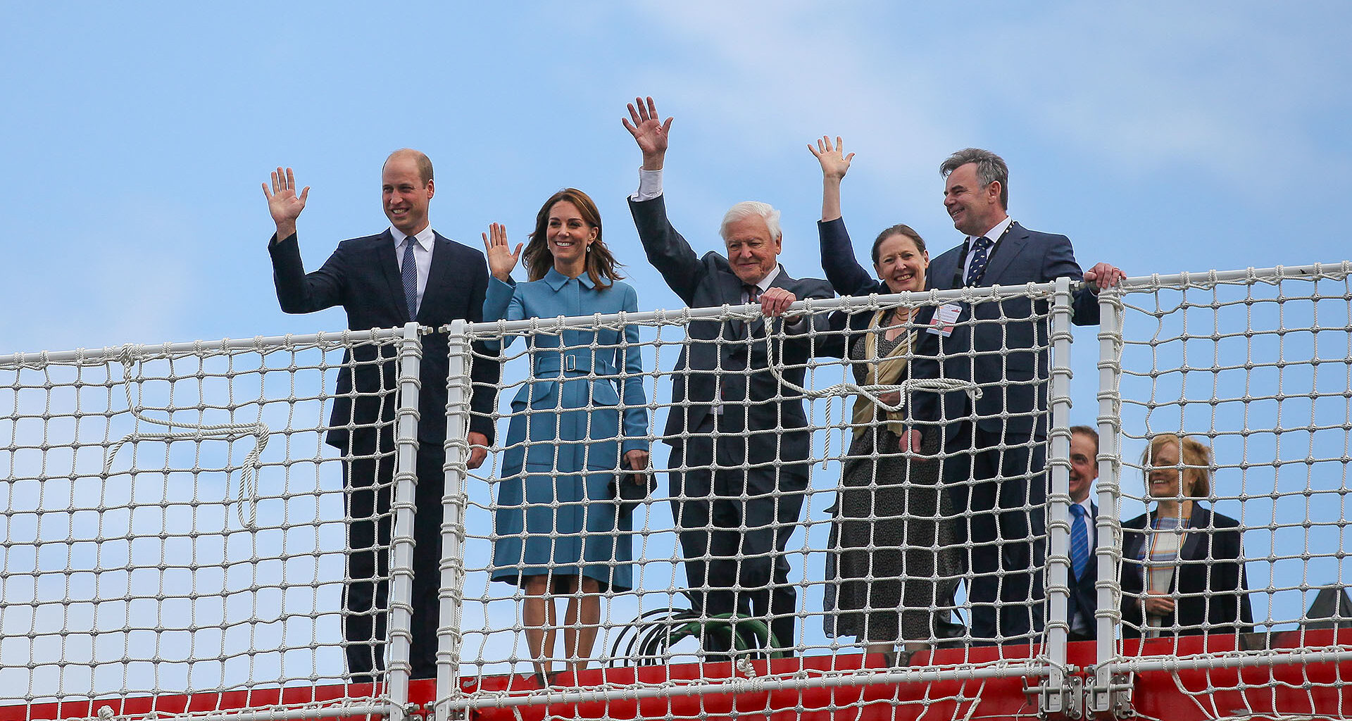 Prince William, Duke of Cambridge, David Attenborough et al. waving from bow of the research ship Sir David Attenborough.