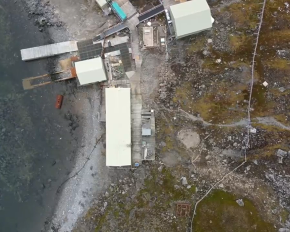 A collection of rectangular buildings on the coast of South Georgia as seen from a drone.