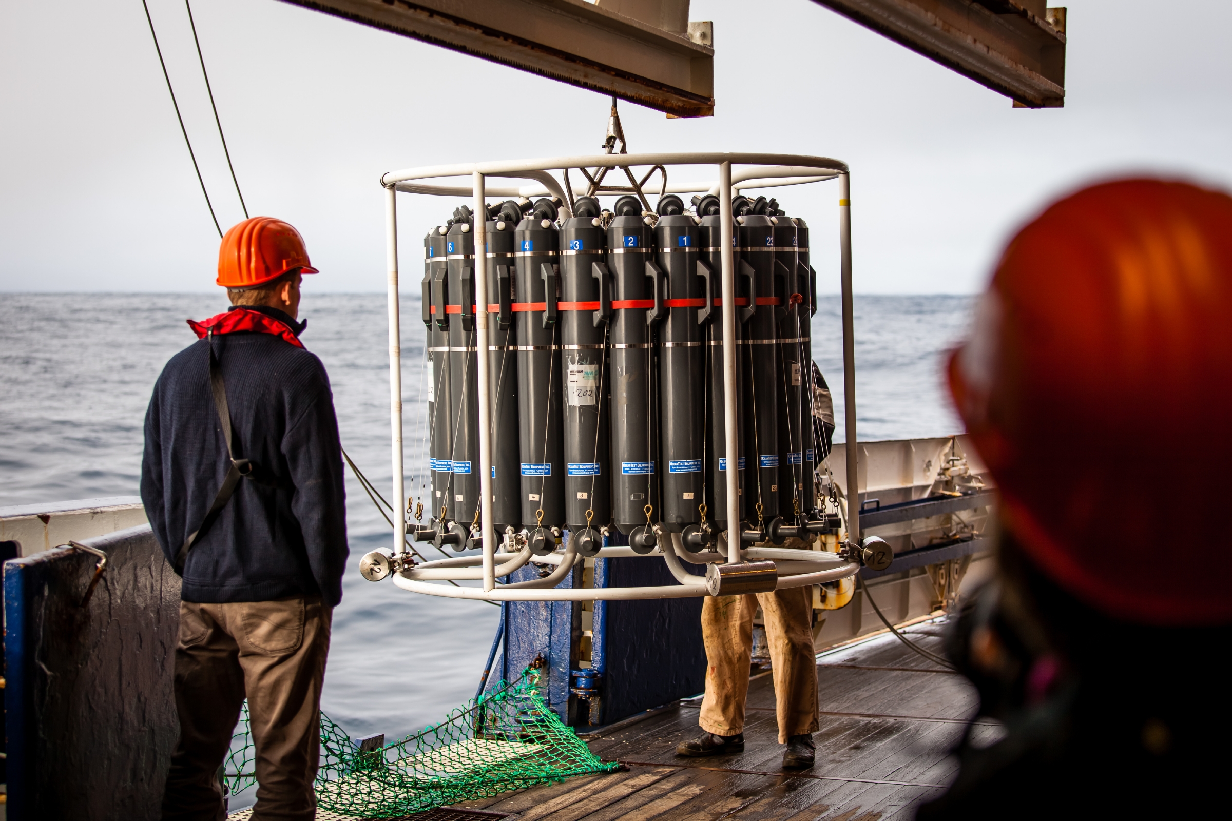 A man standing on a boat with scientific equipment