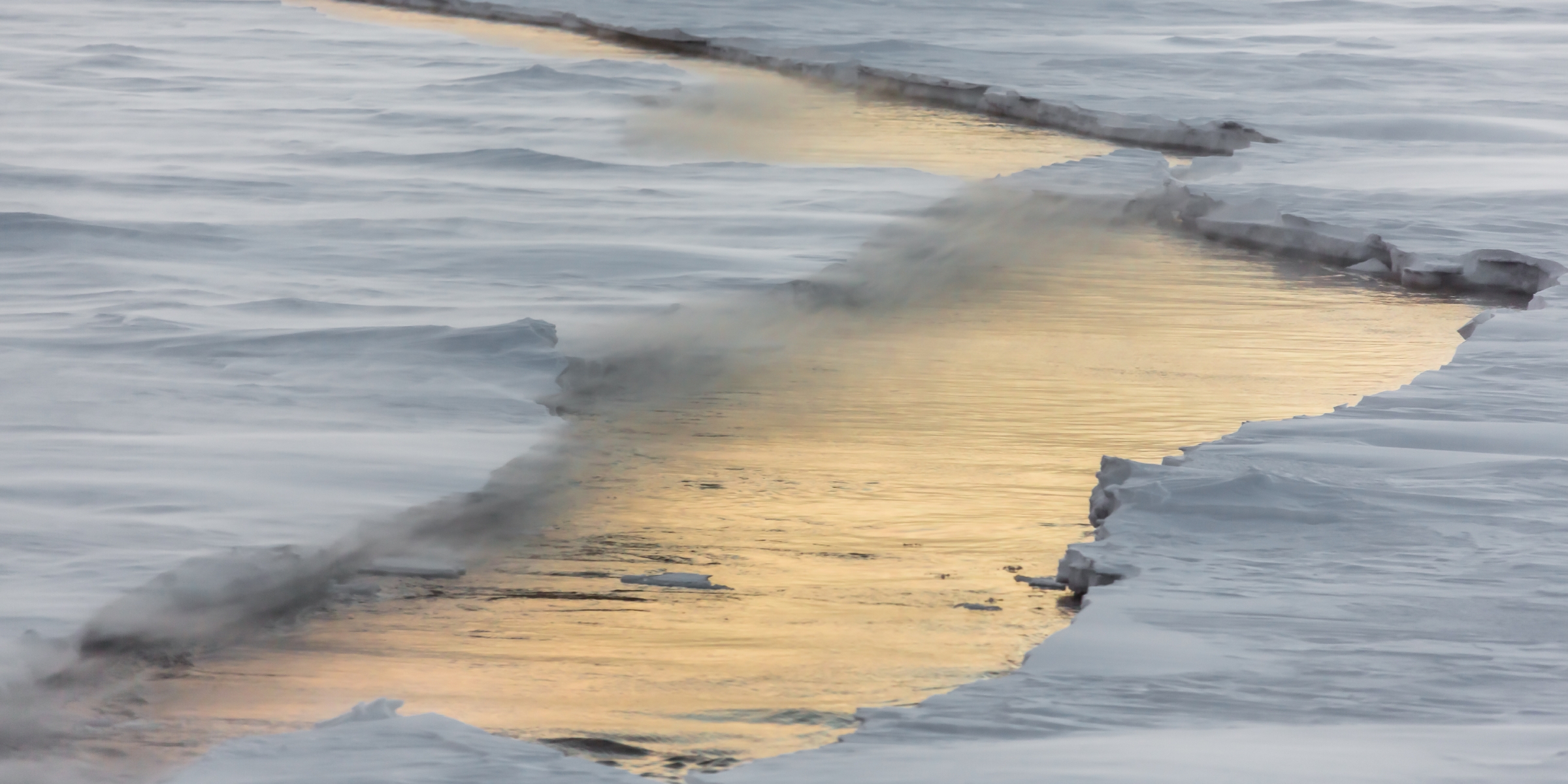 A wave on top of an icy ocean