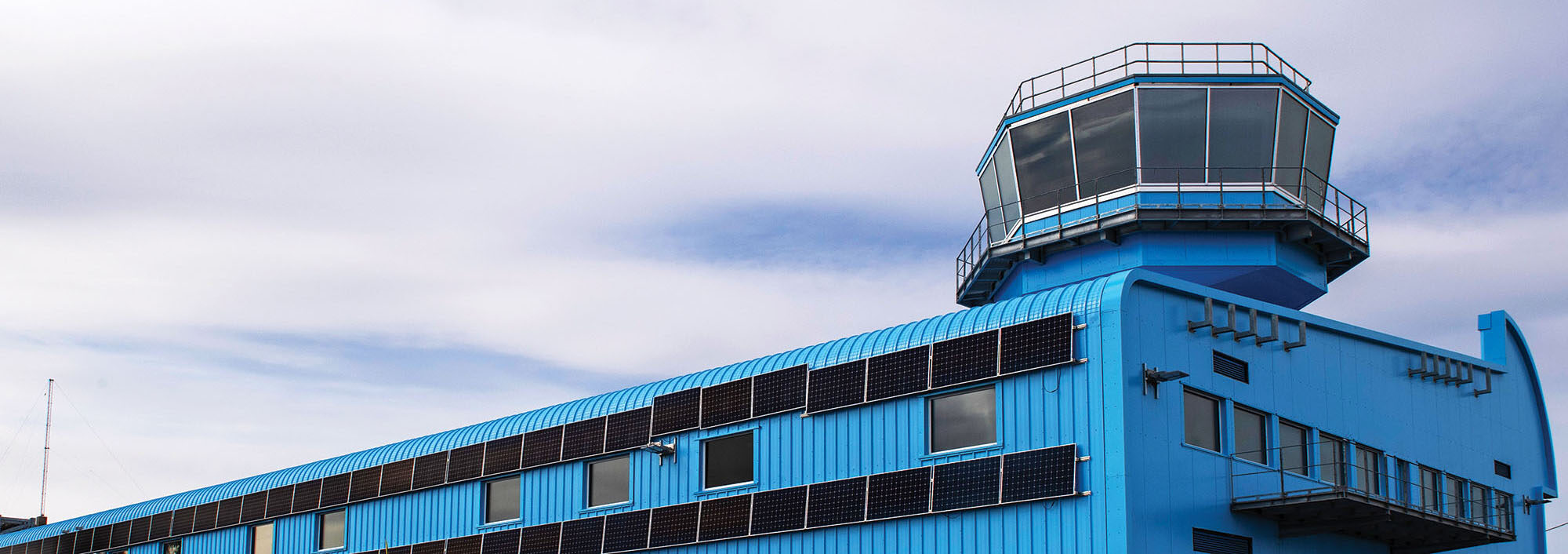 Blue building against a cloudy sky