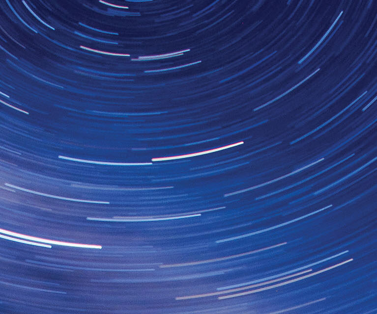 A dark sky with short bright lines in